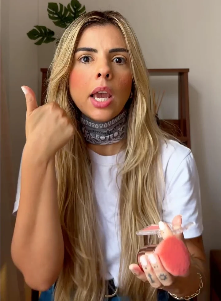 Rayssa falando para a câmera com maquiagem e esponja na mão